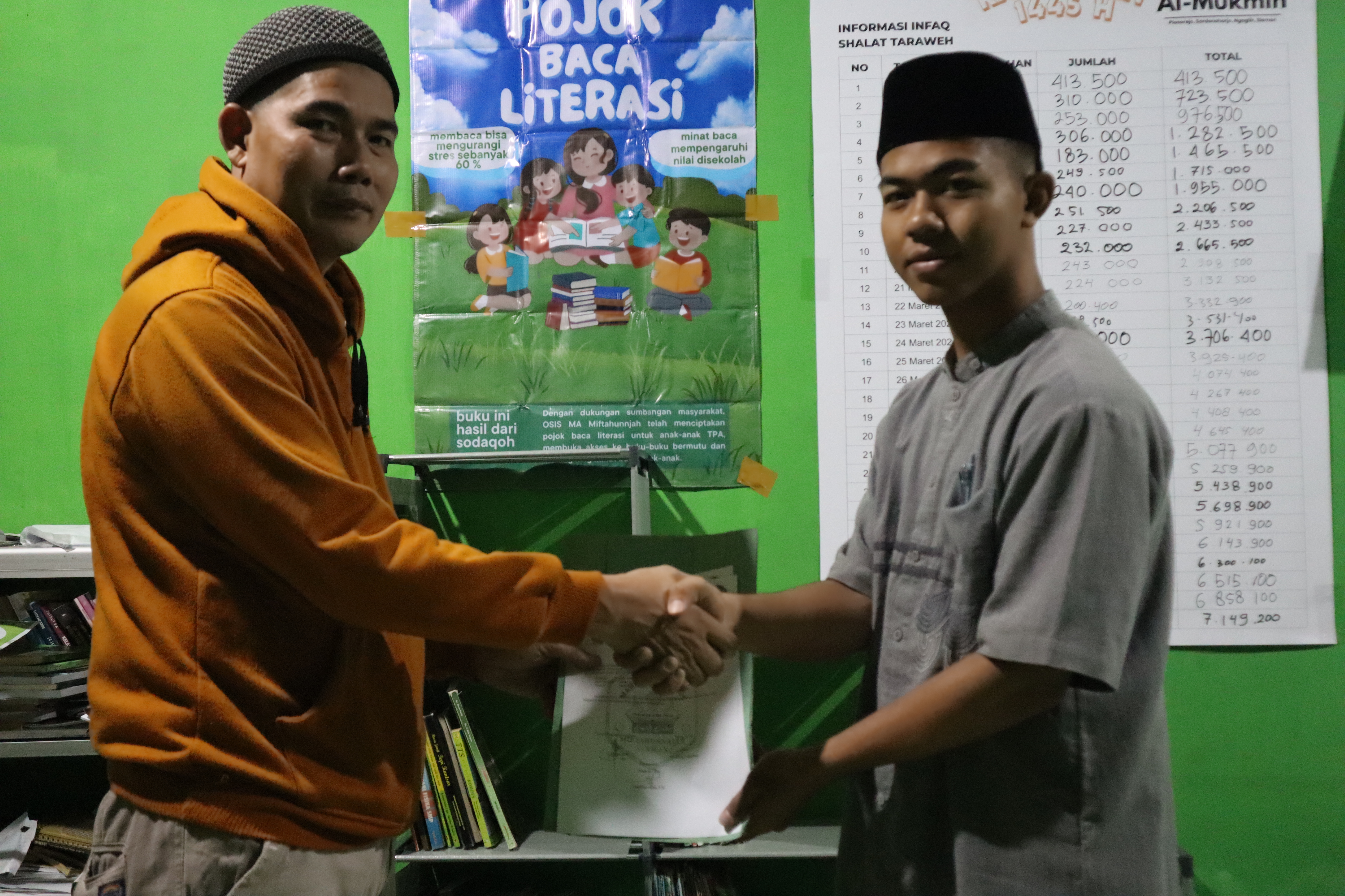 Koordinator Divisi Syiar Dakwah OSIS MA MIftahunnajah Menyerahkan secara simbolis Donasi buku kepada takmir masjid Al-Mukmin bapak Safrudin, S.Pd